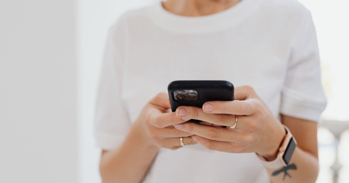 Personne lisant un SMS marketing sur son smartphone, une alternative au mobile wallet marketing
