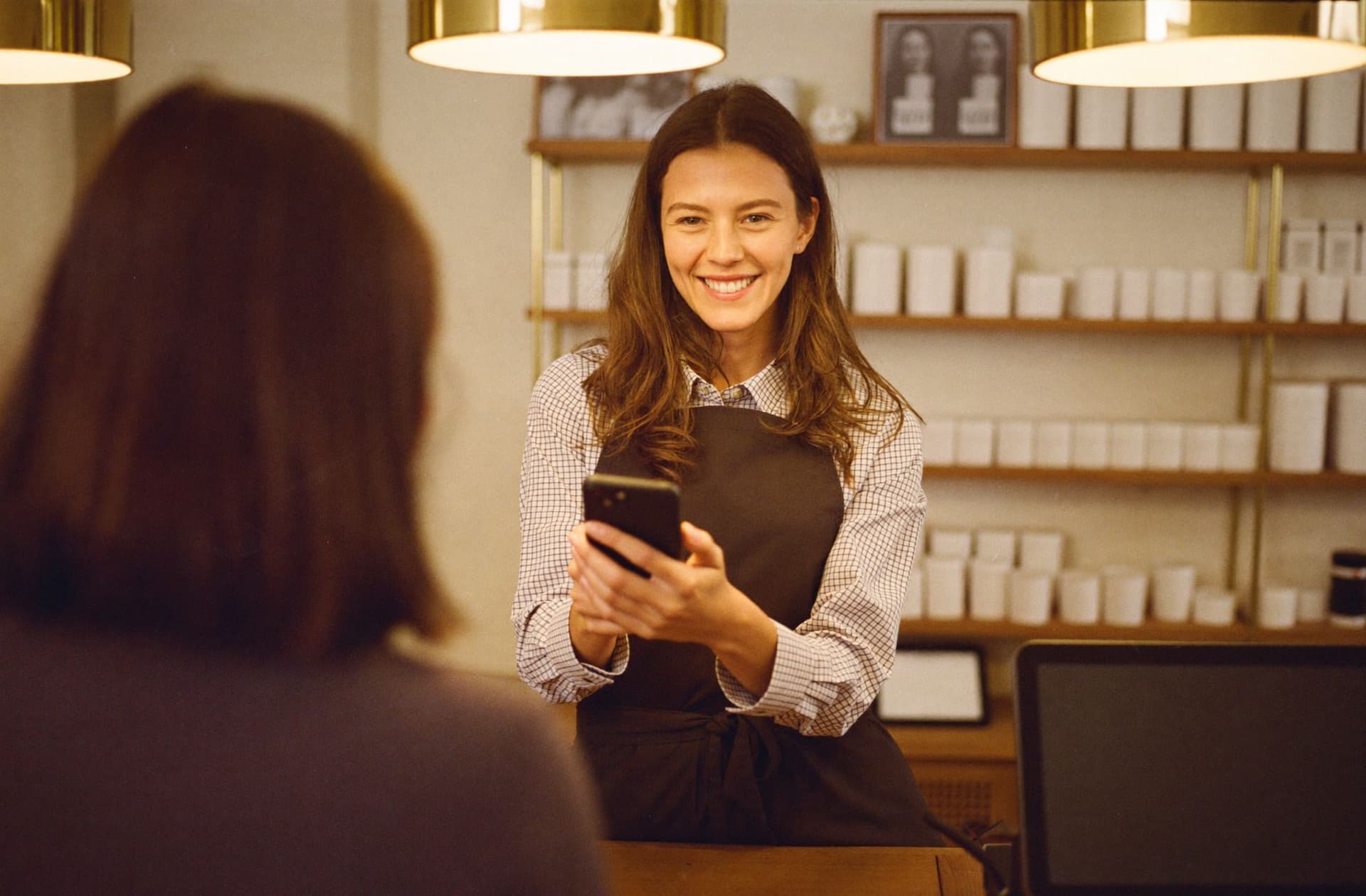 Une commercante montre le mobile wallet marketing à sa cliente